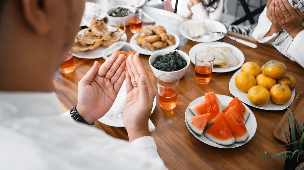 Fasting people gathered around a table praying, and healthy food is on the table.