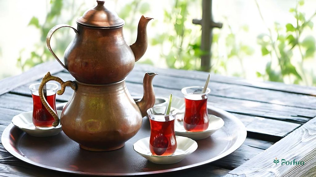 قوری و کتری چای و سه فنجان چای در یک سینی گرد مسی