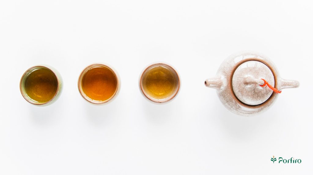 سه فنجان چینی حاوی چای سبز و یک قوری چینی