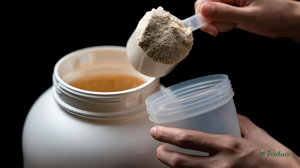 A hand is pouring protein powder from its barrel into a shaker.