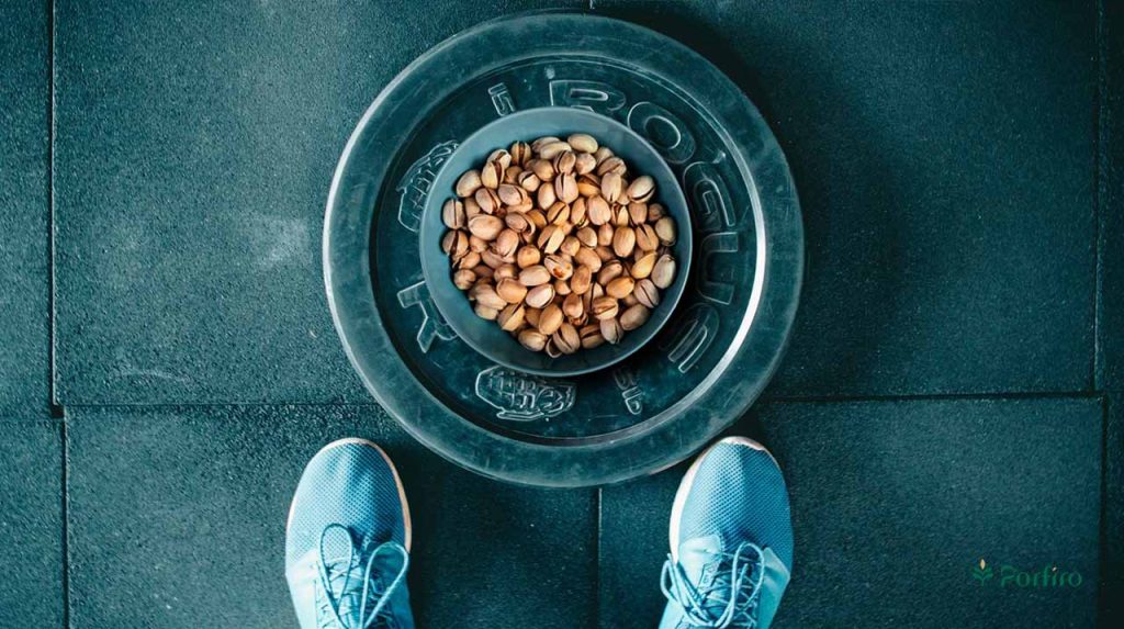 The athlete's feet, with some pistachios poured into the hollow of the bowl in front of them.