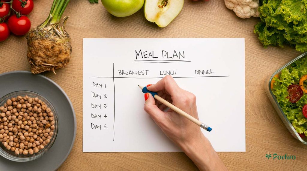 A woman's right hand with red nail polish holding a pencil and planning meals on paper, which includes various foods from vegetables and legumes.