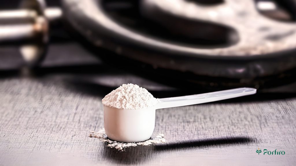 A scoop of supplement powder on the floor next to weights at the gym.