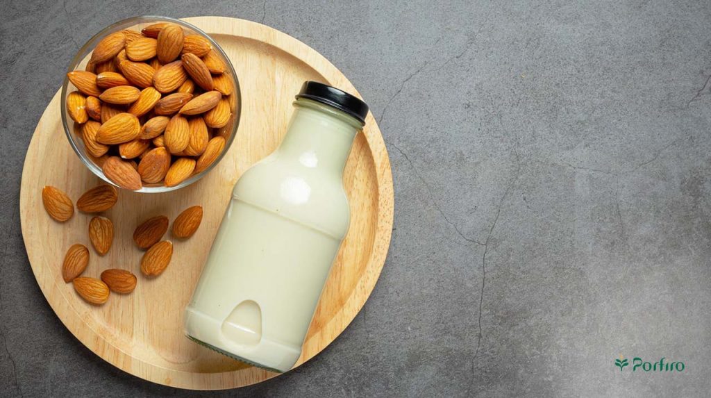Almonds in a bowl and a bottle of almond milk
