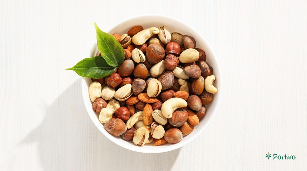 A white clay pot of a mixture of nuts in the article The Properties of Nuts in Porfiro