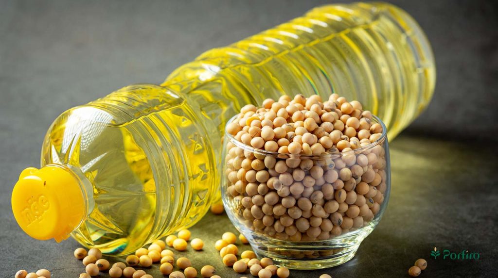 A bottle of soybean oil next to a bowl full of soybeans, one of the most common food allergens.