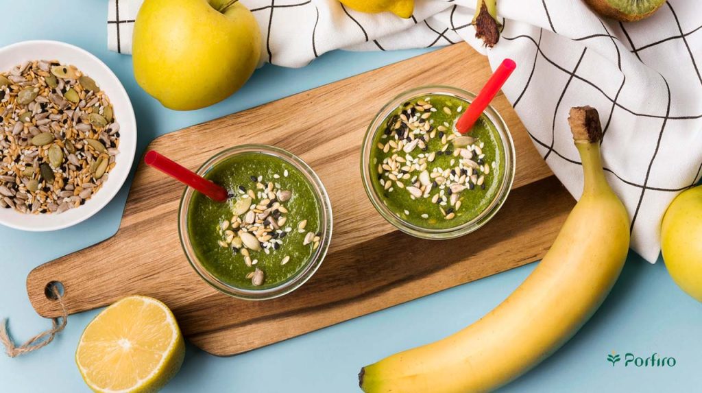Two glasses of healthy smoothie made with bananas and various nuts and seeds