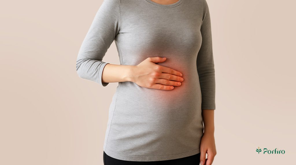 A pregnant woman has her hand on her liver area.