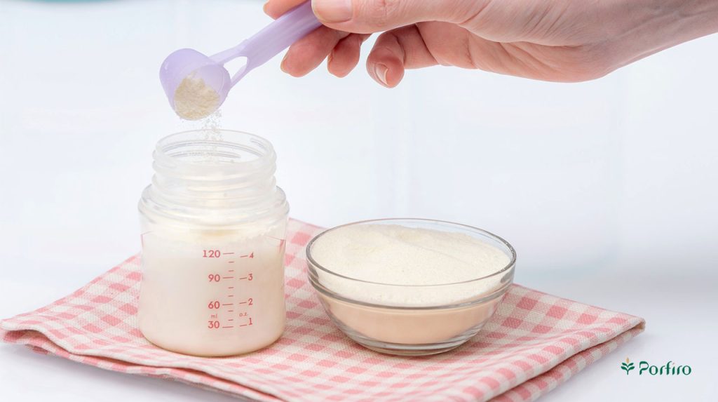 پودر شیر خشک در حال ریختنه شدن در شیشه شیر و آماده شدن برای تغذیه نوزاد