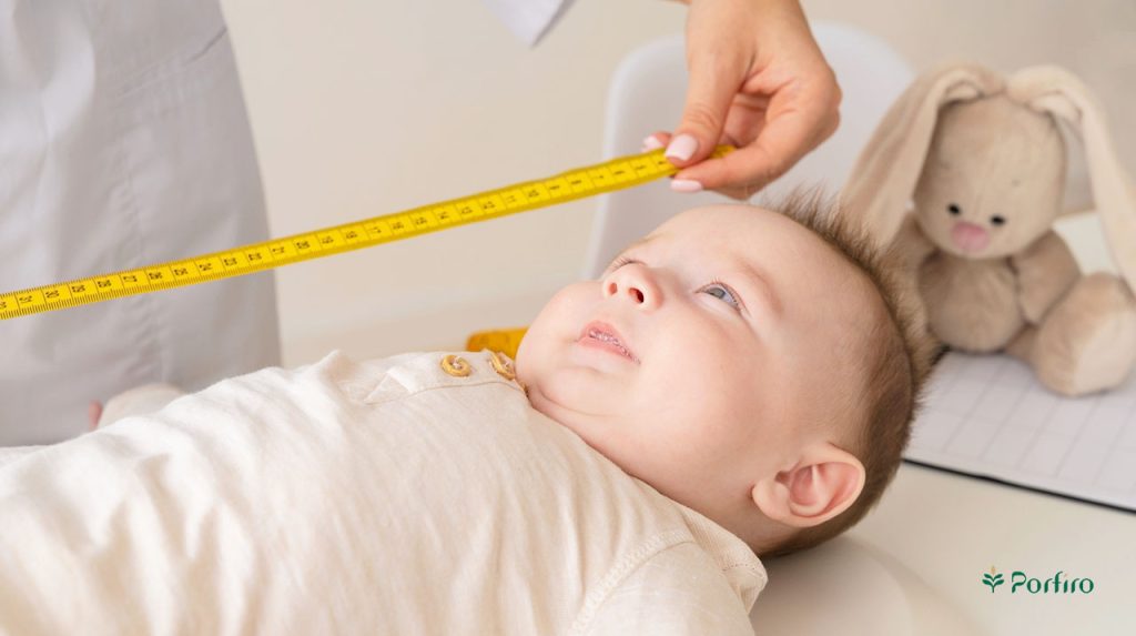 مراقب سلامت در حال اندازه گیزی قد نوزاد با استفاده از متر