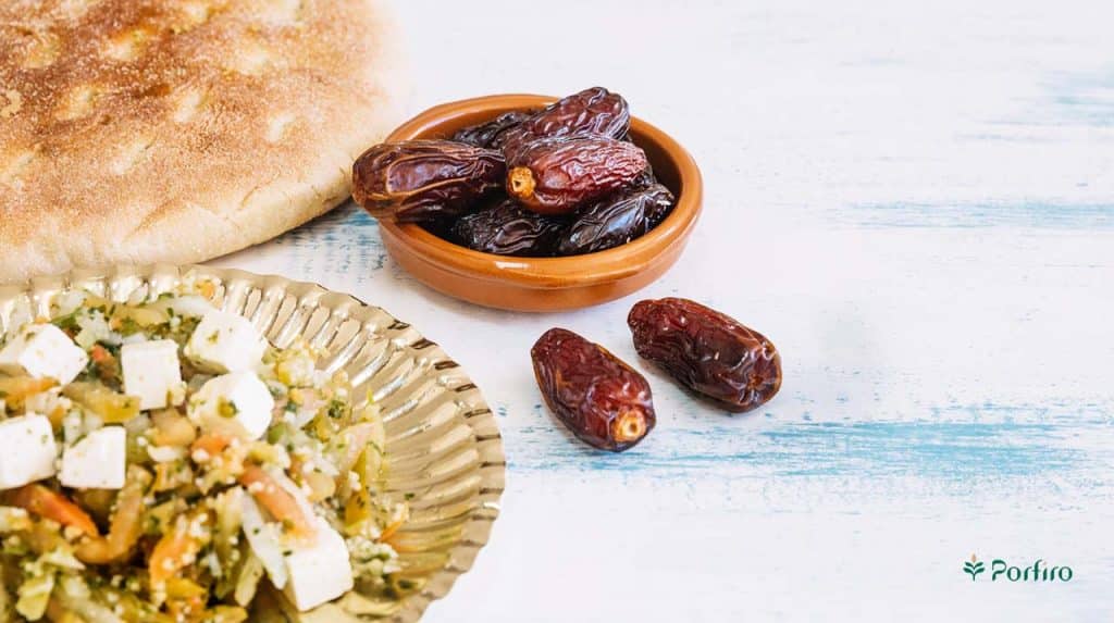 A few dates next to a plate of cheese and bread for Consumption of Dates in the Morning