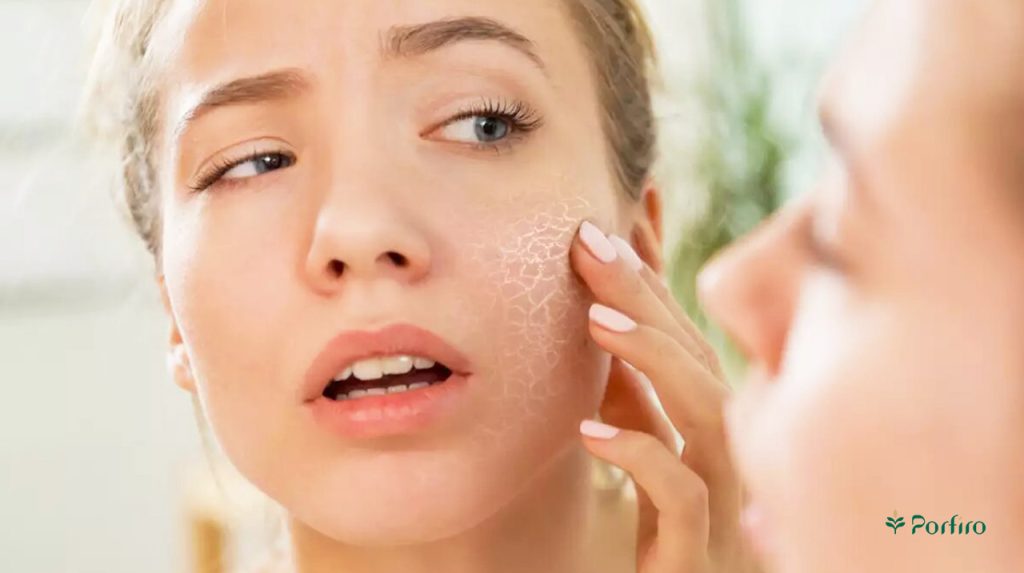 A woman looking at her dry skin in the mirror.