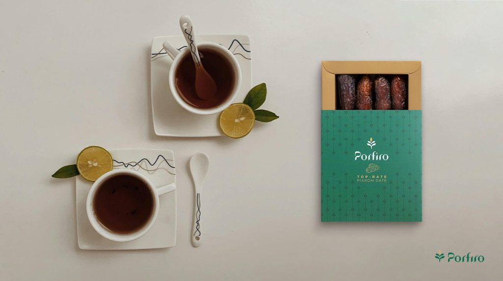Two cups of tea with an open package of Porfiro dates