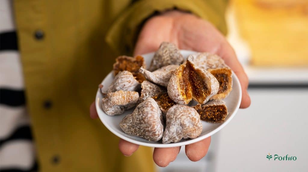 A dish of honeyed figs in a person's hand as a compliment