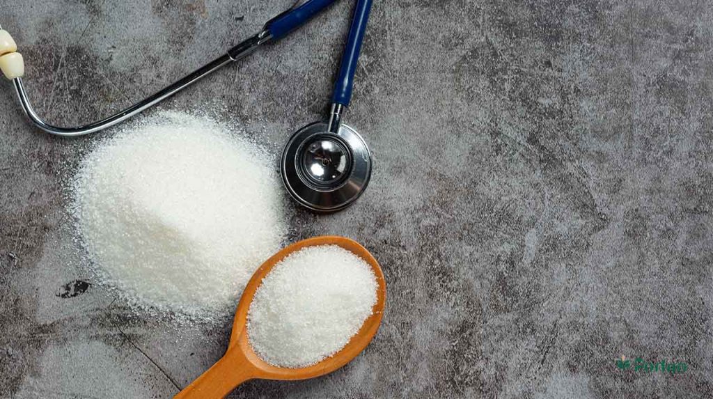 A wooden spoon full of salt next to a stethoscope.