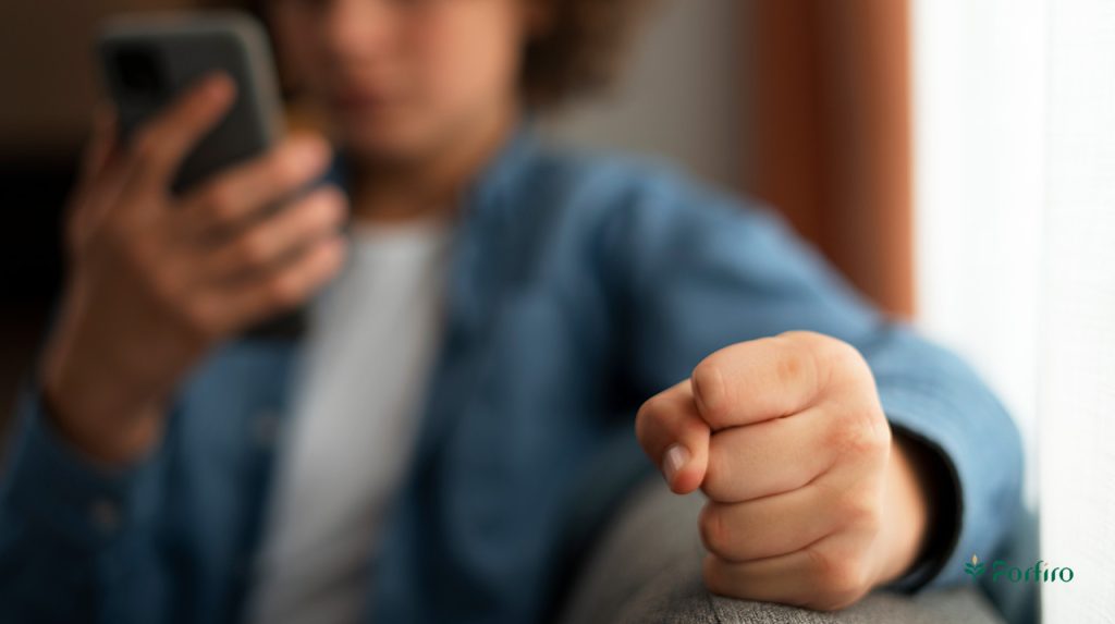 A cyberbullied person is checking social media on his phone.