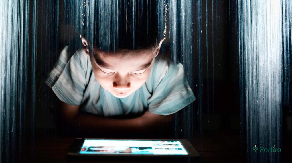 A child focused on the tablet screen with all his senses