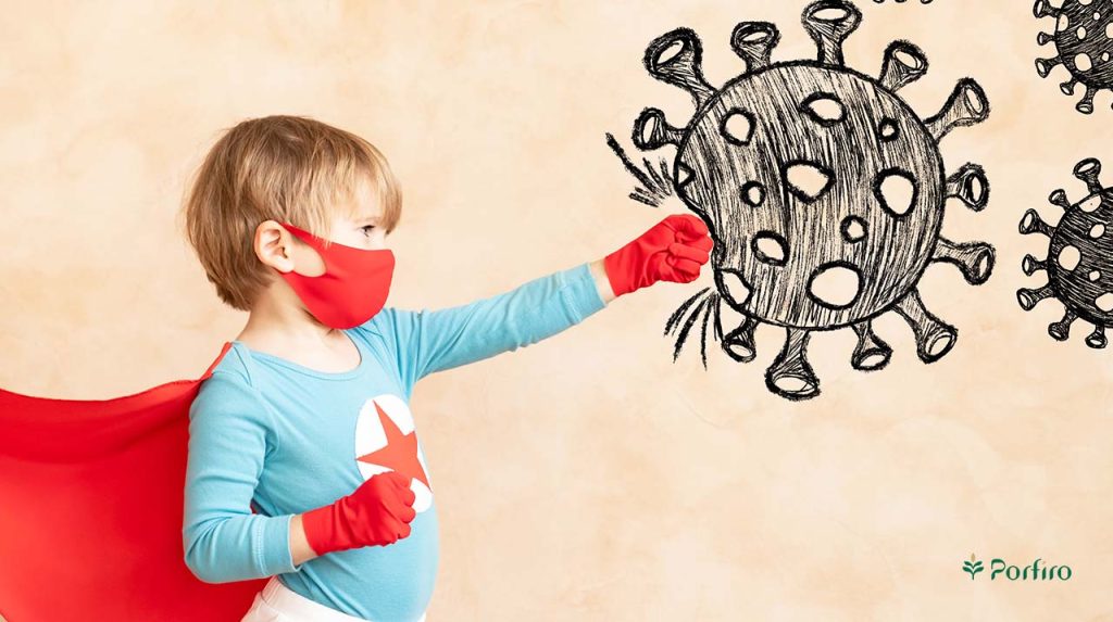 Little boy in knight costume punching a drawing of a virus to fight it