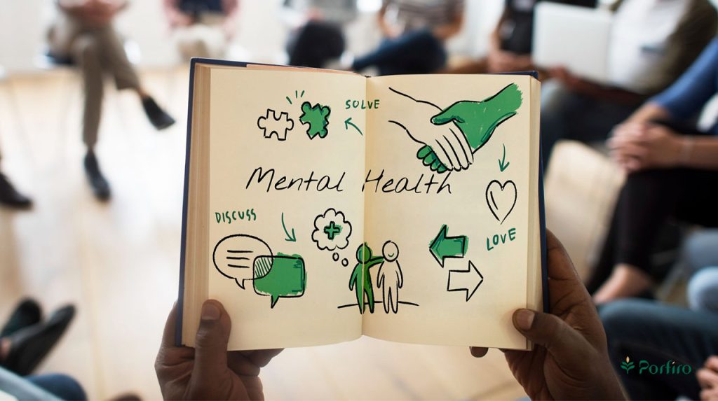 A person sits in a counseling circle and holds a notebook with mental health elements drawn on it.