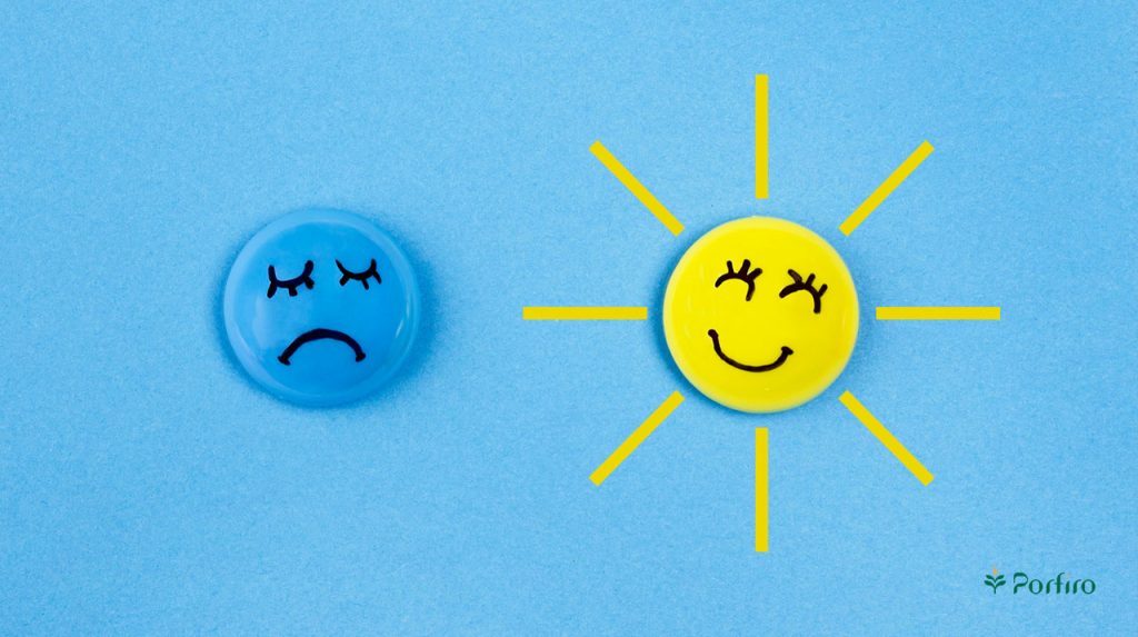 A drawing of a smiling sun on the right and a depression emoji on the left to express the connection between the new sun and depression in the article "The Benefits of Sunlight" on Porfiro's blog.